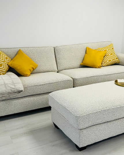 Bloomsbury luxury cream sofa with yellow cushions and matching footstool in modern living room.