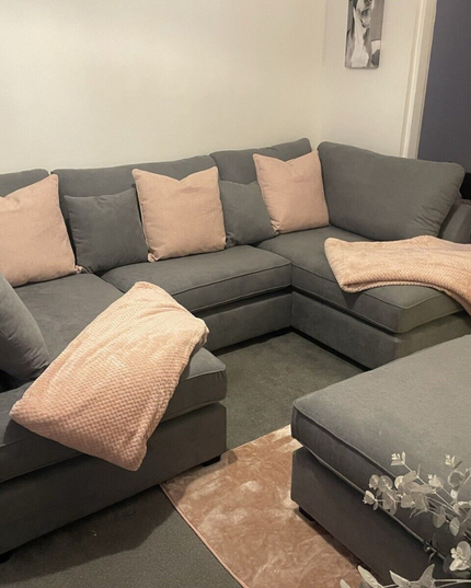 Carnaby small U shape sofa in gray with pink cushions and footstool, designed for comfort and style.