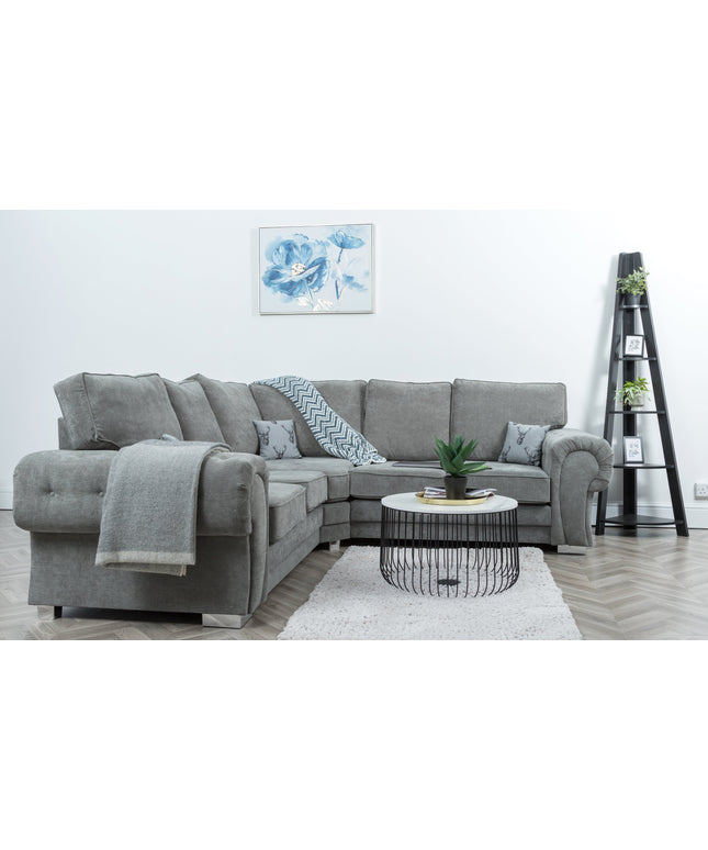 Vegas modular corner sofa in grey fabric with pillows, coffee table, and floral wall art in a modern living room.