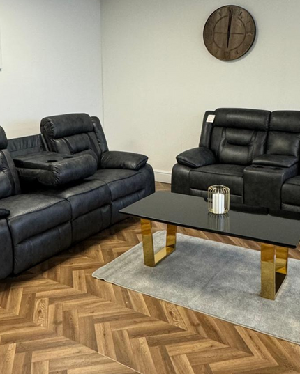 Elegant Nova 3+2 electric recliner sofa set in dark grey aire leather, with a stylish coffee table and decorative accents.