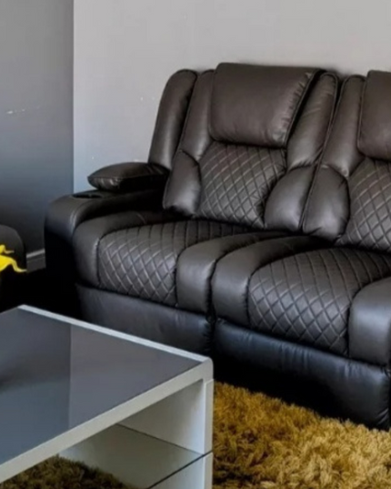 Orlando 2-seater electric recliner sofa in grey leather with cupholders and drop-down table, styled with a vase of yellow flowers.