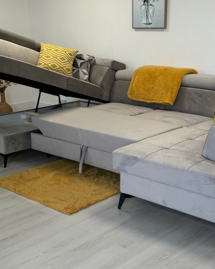 Sovereign U-shaped pull-out sleeper sofa in plush gray velvet with yellow cushions, showcasing a modern living room setup.