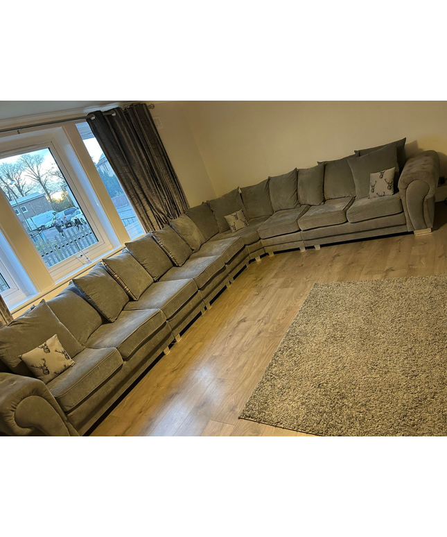 Verona corner sofa in soft grey fabric, 9-seater design, arranged in a cozy living room setting.