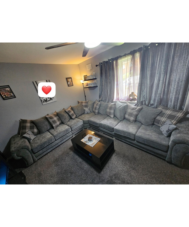 Spacious Verona 8-seater corner sofa in grey with cushions, perfect for cozy gatherings in a stylish living room.